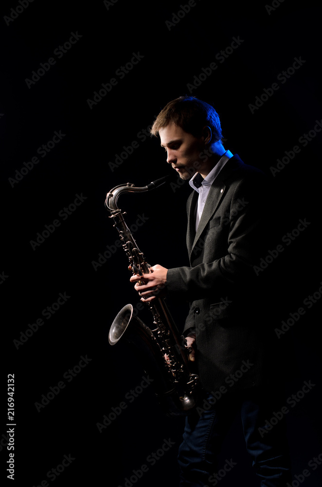Naklejka premium Saxophonist, illuminated by blue and white light