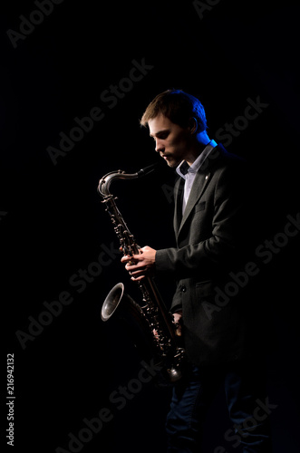 Saxophonist, illuminated by blue and white light