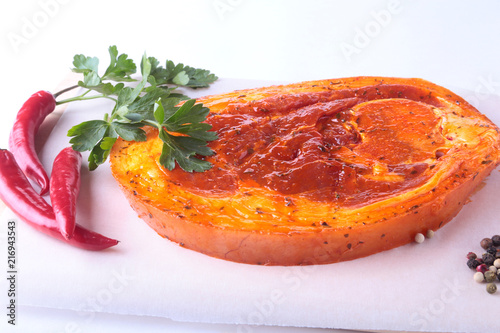 Raw Pork ham with spices, parsley leaves and chilli ready for BBQ grilling isolated on white background. photo