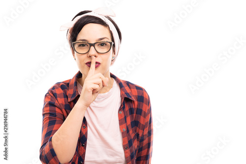 Young pretty pin-up girl wearing glasses showing silent gesture.