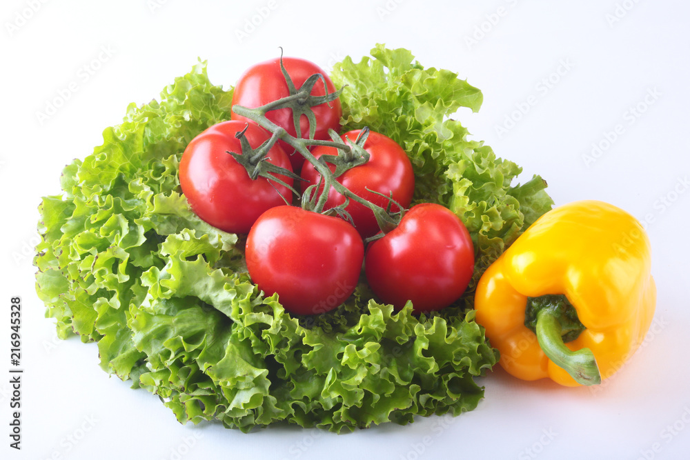 Fresh assorted vegetables bell pepper, tomato, garlic with leaf lettuce. Isolated on white background. Selective focus. Fresh assorted vegetables bell pepper, tomato, garlic with leaf lettuce. Isolated on white background. Selective focus.