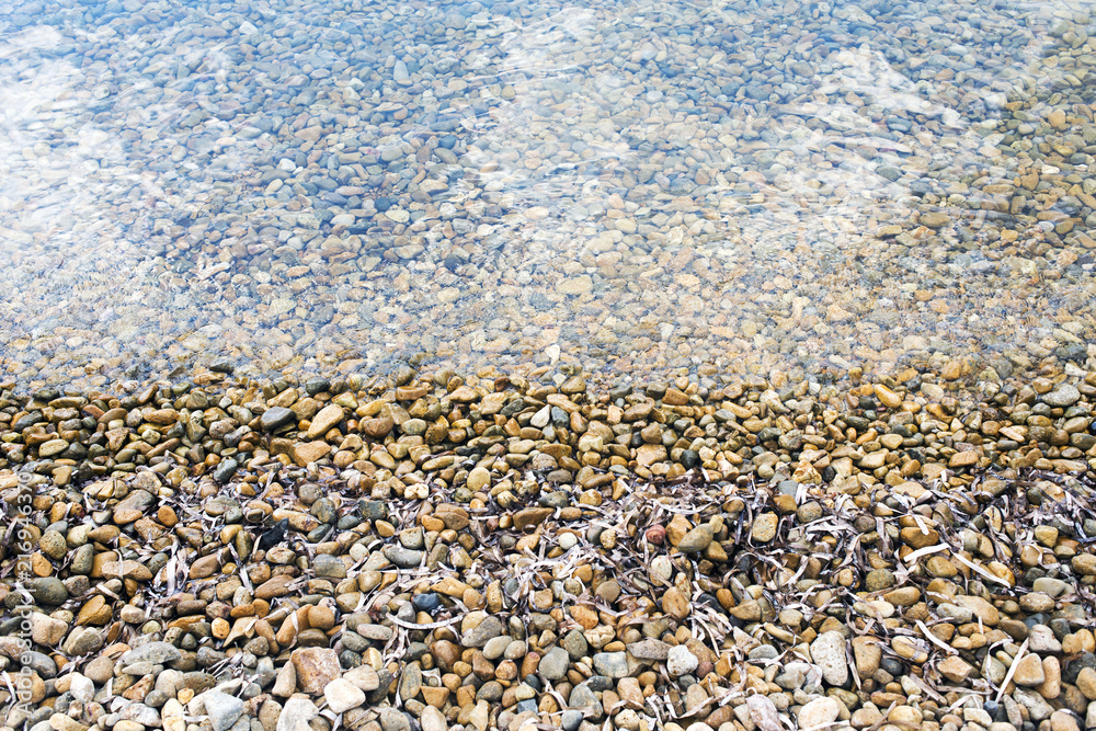 A view of sea and stones in the beautiful beach in the island of Patmos, Greece in summer time A view of sea and stones in the beautiful beach in the island of Patmos, Greece in summer time