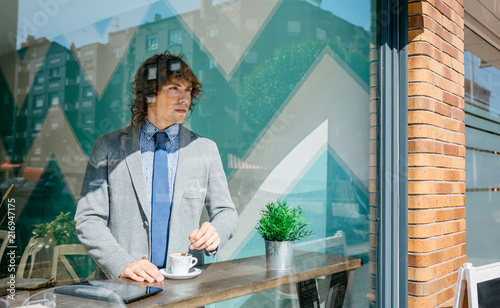 Businessman stirring coffee in a coffee shop photo