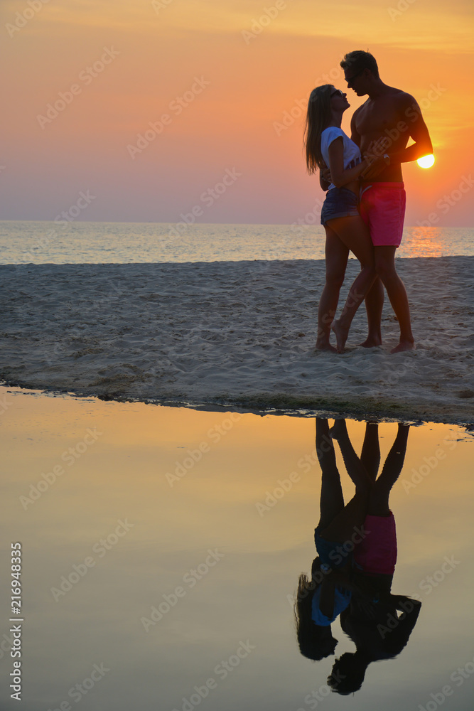 A loving couple watching the sunset on the beach