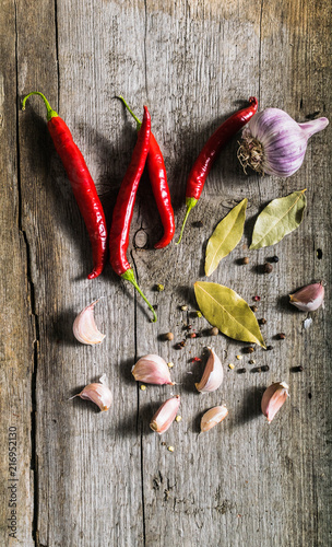 Świeże papryki chili, pieprz i czosnek na drewnianym tle