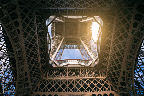 eiffel tower, view from below, tower base close-up, concept of traveling alone and romance, sunbeam