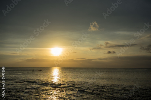 Ocean Sunset in Bali  Indonesia with small boats on water
