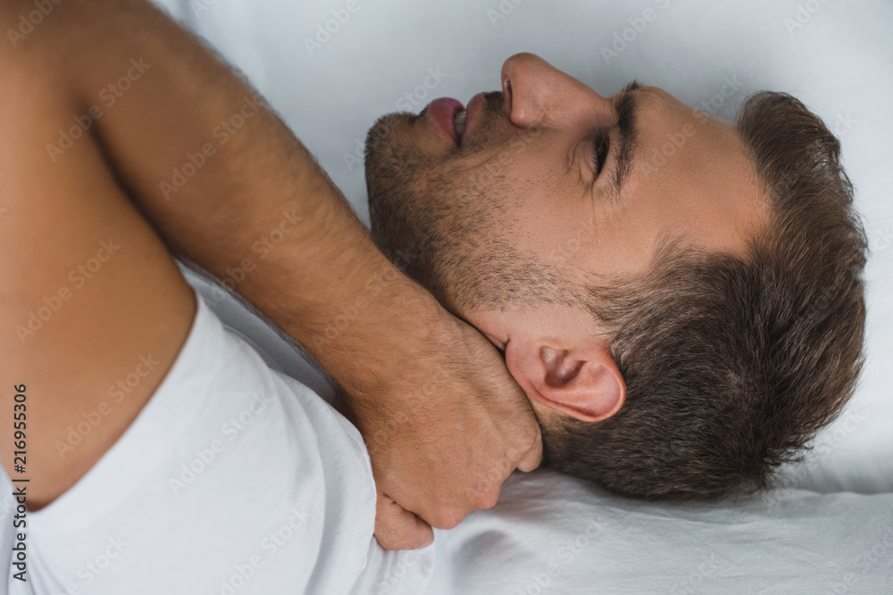 man lying in bed and suffering from pain in neck man lying in bed and suffering from pain in neck