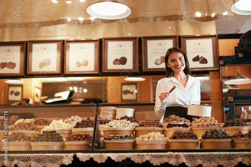 Chocolate Store. Female Seller In Confectionery Shop. photo