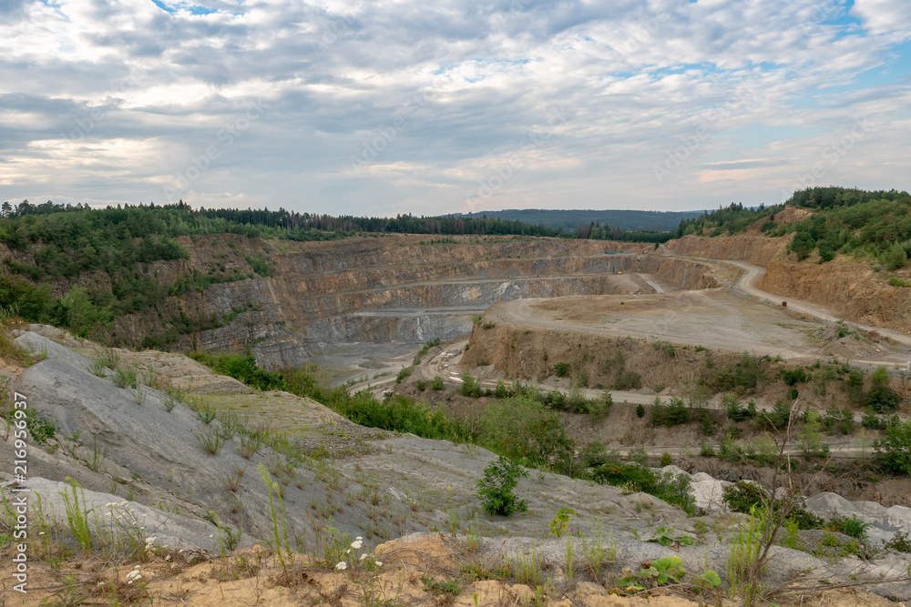 Opencast mining quarry with machinery. Quarrying of stones for construction works. Mining industry in quarry.