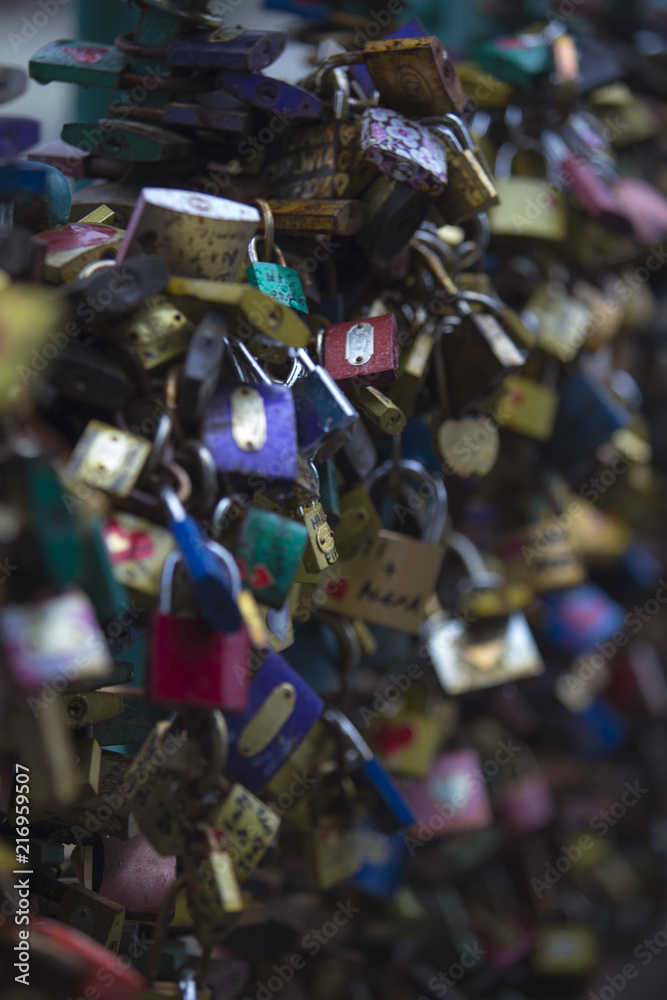 thousands of colored padlocks on the emerald iron fence of the bridge

