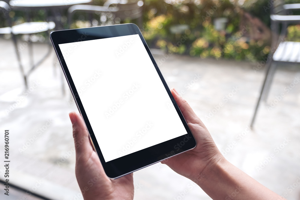 Mockup image of woman's hands holding black tablet pc with white blank desktop screen in cafe Mockup image of woman's hands holding black tablet pc with white blank desktop screen in cafe