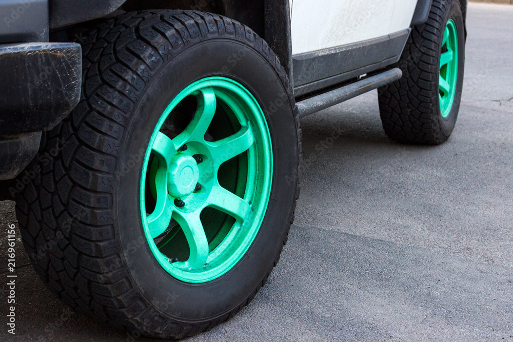 jeep with green wheel disks on the road