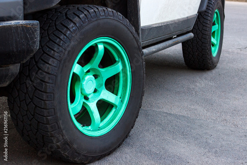 jeep with green wheel disks on the road © sosiukin