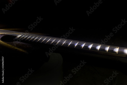 The tuning end of a guitar isolated on a black background.
