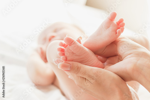 Hands of woman holds baby feet