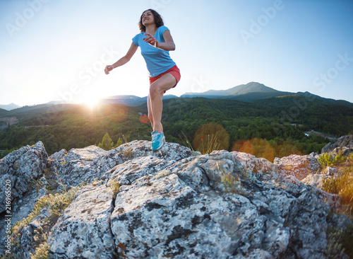 A girl is running in the mountains.