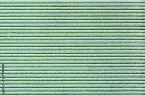 Green relief striped stone wall. texture strip wall, surface, background, decorative plaster