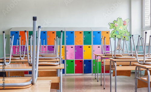 Empty Classroom with colorful lockers and raised chairs on the tables
