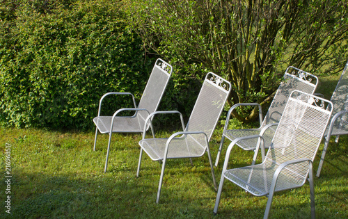 Metallic silver chairs in park on grass