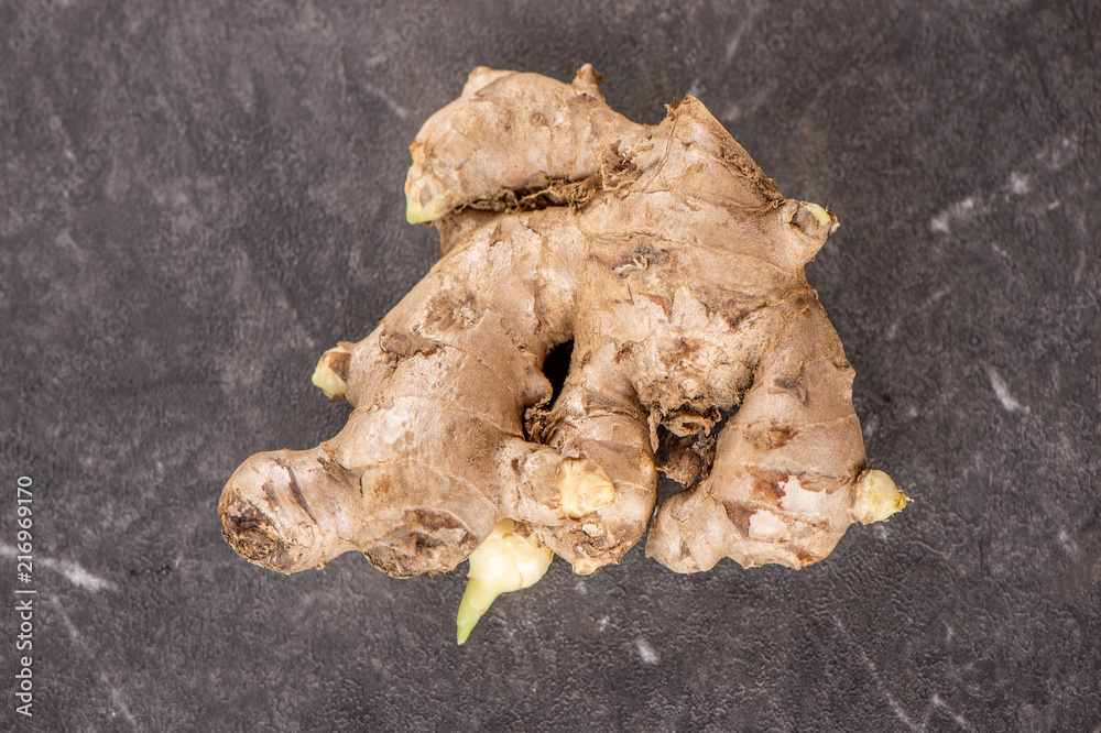 Whole ginger roots on dark old stone background table, space for text. Whole ginger roots on dark old stone background table, space for text.