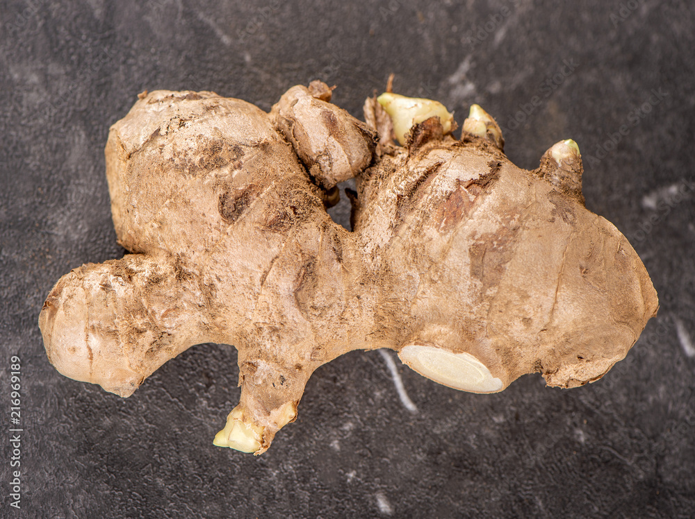 Whole ginger roots on dark old stone background table, space for text. Whole ginger roots on dark old stone background table, space for text.