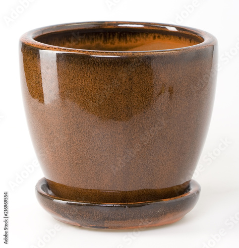 Glazed brown ceramic flowerpot with saucer on white