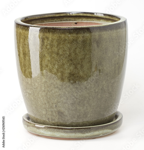 Glazed green ceramic flowerpot with saucer on white