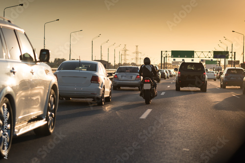 Traffic jam on a hot summer evening. Highway and road junction. Sunset cars and moto