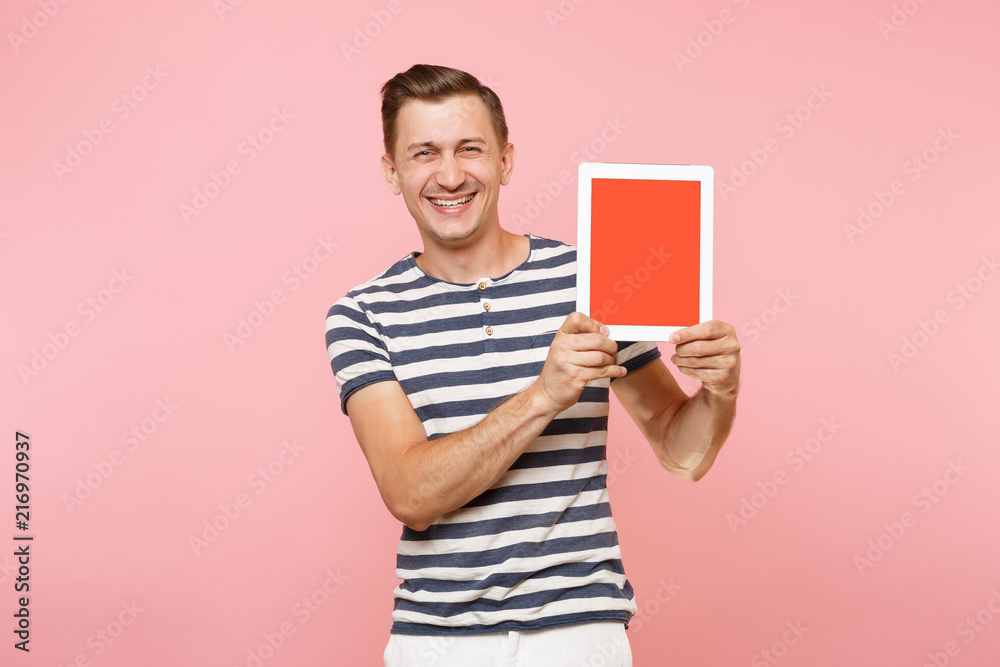 Portrait of young man holding tablet computer with blank black empty screen display touchscreen copy space isolated on trending pastel pink background. Technology lifestyle concept. Advertising area. Portrait of young man holding tablet computer with blank black empty screen display touchscreen copy space isolated on trending pastel pink background. Technology lifestyle concept. Advertising area.