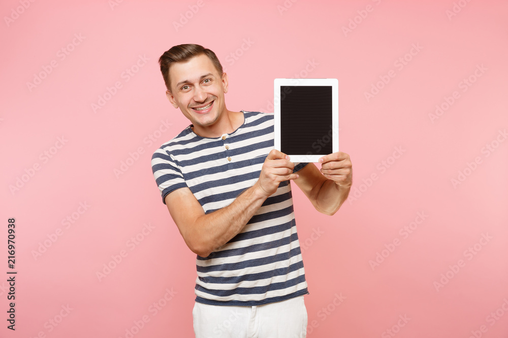 Portrait of young man holding tablet computer with blank black empty screen display touchscreen copy space isolated on trending pastel pink background. Technology lifestyle concept. Advertising area. Portrait of young man holding tablet computer with blank black empty screen display touchscreen copy space isolated on trending pastel pink background. Technology lifestyle concept. Advertising area.