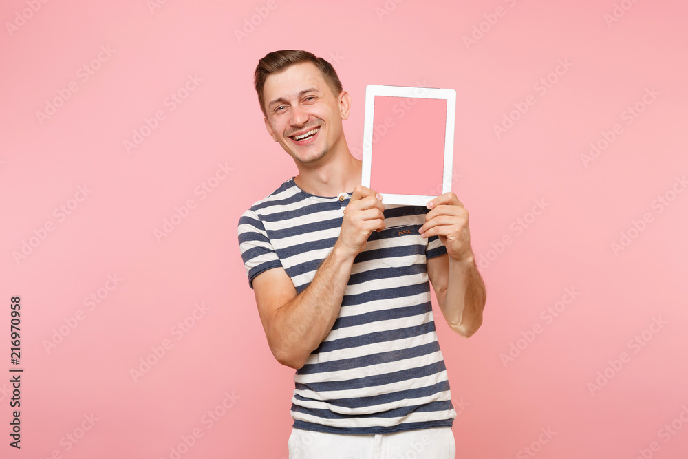 Portrait of young man holding tablet computer with blank black empty screen display touchscreen copy space isolated on trending pastel pink background. Technology lifestyle concept. Advertising area. Portrait of young man holding tablet computer with blank black empty screen display touchscreen copy space isolated on trending pastel pink background. Technology lifestyle concept. Advertising area.