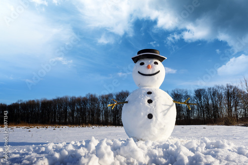 Funny snowman in stylish black hat on snowy field. Merry Christmass and happy New Year!