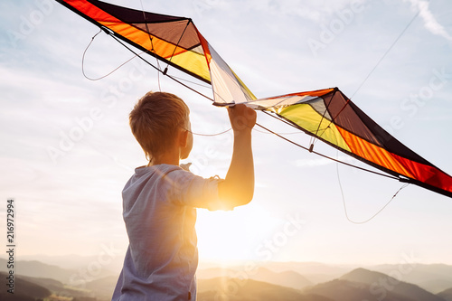 Boy prepare to fly a kite over the mountain hills photo