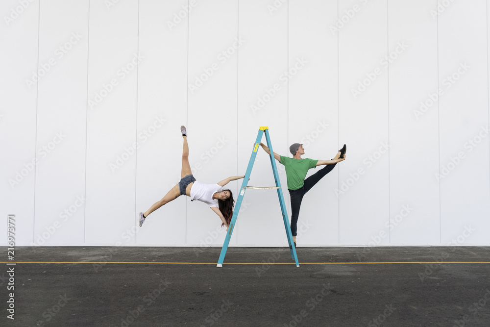 © Westend61 - Two acrobats doing tricks on ladder © Westend61 - Two acrobats doing tricks on ladder