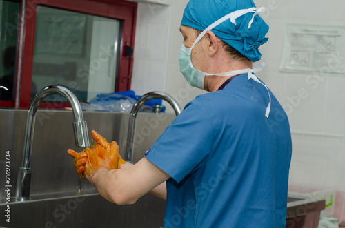 Surgeon is watching his hands ecording to sterilization rules.