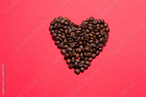 Grains of coffee in the form of heart on a red background