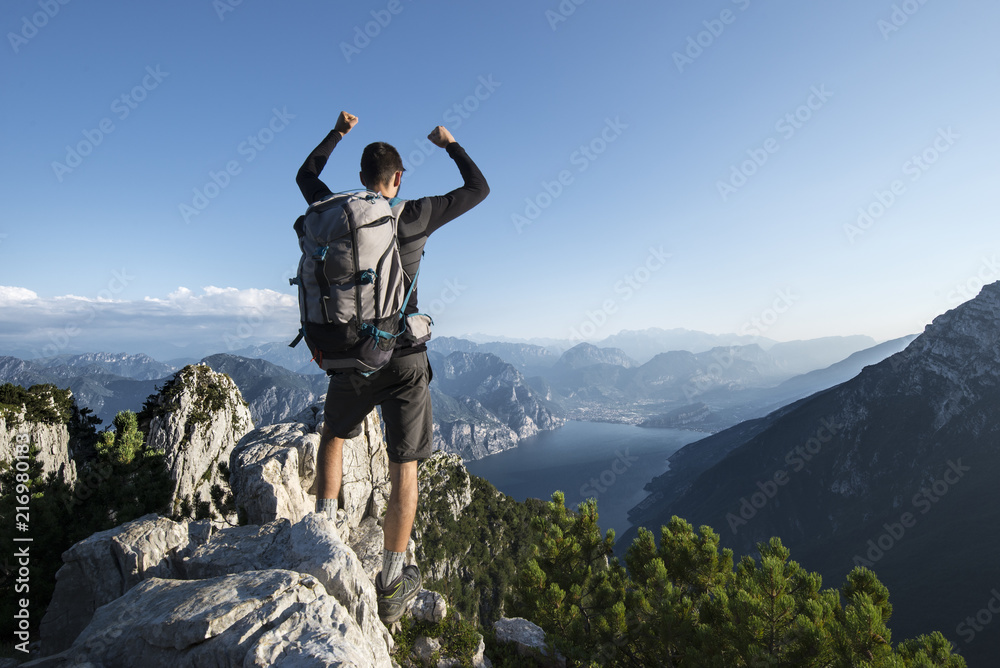 Hiker at the top of the trekking trail with a beautiful lake view