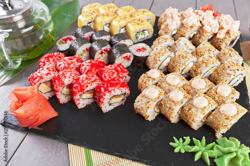 Sushi rolls set served on slate on dark background