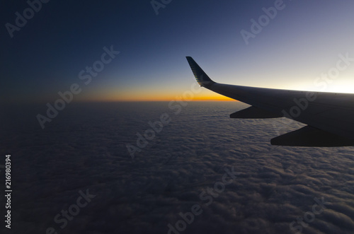 paisaje de atardecer sobre las nubes con ala de avion en primer plano