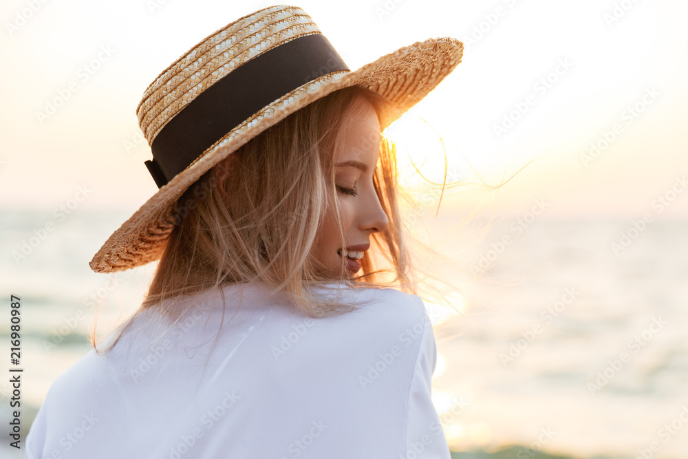 Blonde woman wearing hat outdoors at the beach