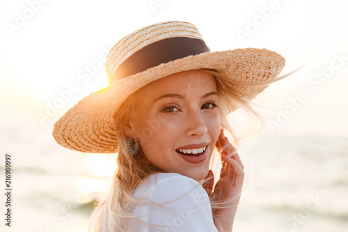 Cute blonde woman wearing hat outdoors at the beach