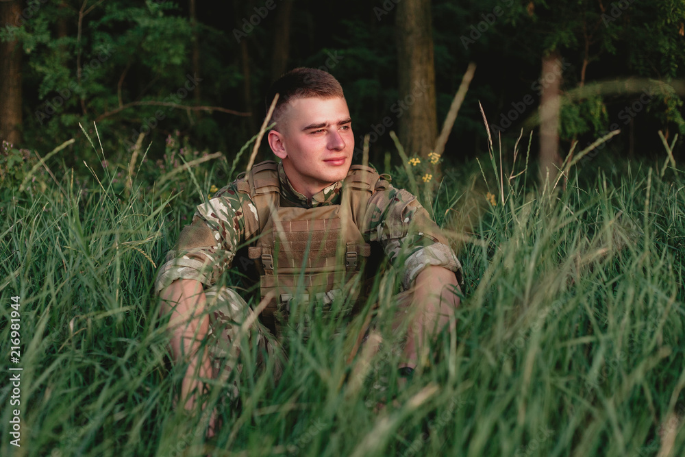Soldier man standing against a field. Portrait of happy military soldier in boot camp. US Army soldier in the Mission