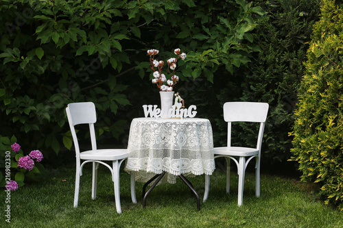 A table for two, with a white tablecloth on the nature, with an inscription wedding