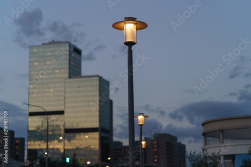 Street lamps light at the sunset. Image with defocused background