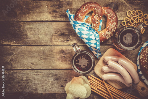 Oktoberfest concept - traditional food and beer on rustic background photo