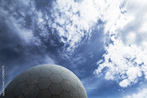 White radar ball under dramatic cloudy sky