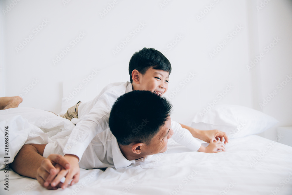 Happy family. Dad and son playing and laughing in bed room. Happy family. Dad and son playing and laughing in bed room.