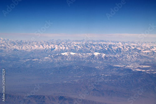 Snowy mountains on blue sky, aerial view. Planet earth natural landscape. Travel around world. Environment protection and ecology. Life is possible only on earth