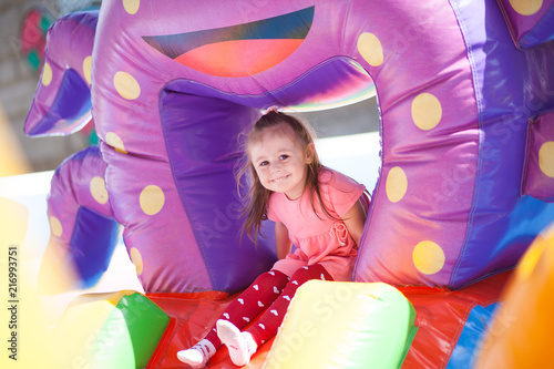 Quadro su tela A cheerful child plays in an inflatable castle